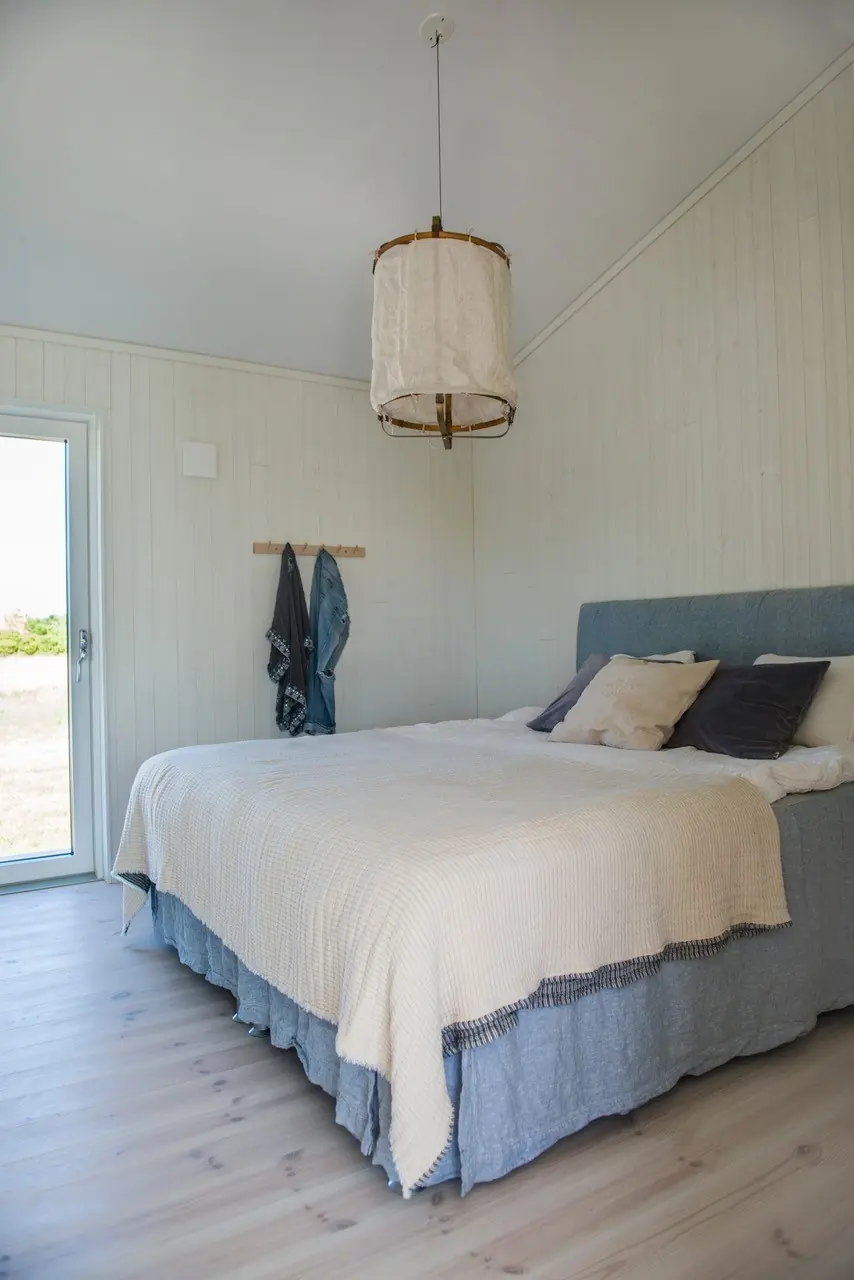 Sovrum med dubbelsäng och glasdörr ut i ett levererat Fårö 74