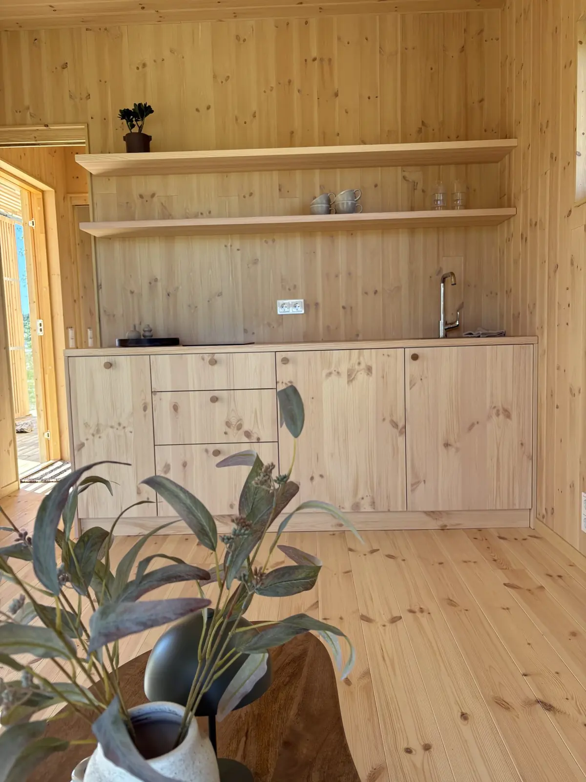 Köket i visningshuset, ett Nära Naturen 30, i ljust trä med öppna hyllor