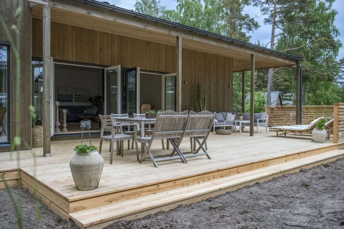 Trädäck med matplats och solsängar en sommardag
